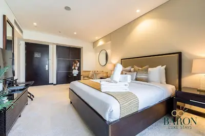 a hotel room with a large bed and a desk at The Signature in Dubai