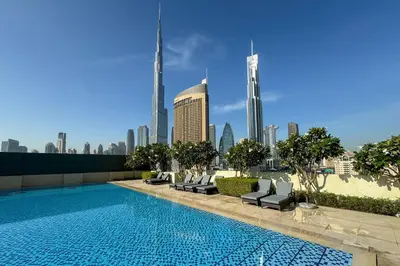 a swimming pool with a city skyline in the background at Luxury 1 Bedroom in the Heart of Famous Downtown in Dubai