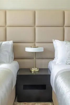 a bed room with two beds and a table between them at Frank Porter - Sunrise Tower in Dubai