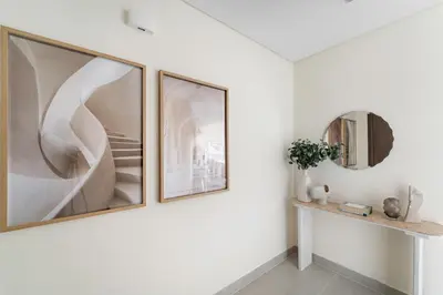 two framed photographs on a wall in a room with a table at 1BR Forte 2, Skyline City View in Dubai