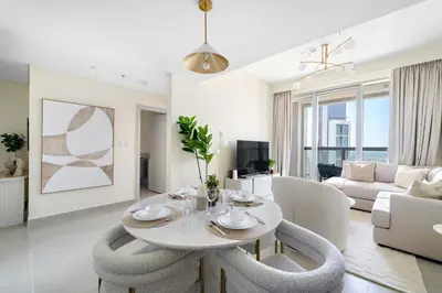 a white living room with a table and chairs at 1BR Forte 2, Skyline City View in Dubai
