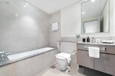 a bathroom with a tub and a toilet and a sink at 1BR Forte 2, Skyline City View in Dubai
