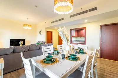 a dining room with a table and a couch at Family & Group Paradise - JBR Beach 3 min walk - Ain Dubai Views - Heart of JBR - 14 People in Dubai