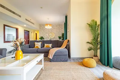 a living room with a couch and a table at Family & Group Paradise - JBR Beach 3 min walk - Ain Dubai Views - Heart of JBR - 14 People in Dubai