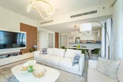 a living room with a white couch and a tv at NEW Exceptional Lagoon View - 2 Stylish Bedrooms in Dubai