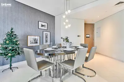 a dining room with a table and a christmas tree at bnbmehomes - DAMAC Towers Paramount in Dubai