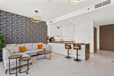 a living room with a couch and a kitchen at Superb 1 Bedroom with Burj Khalifa and Lagoon View in Dubai
