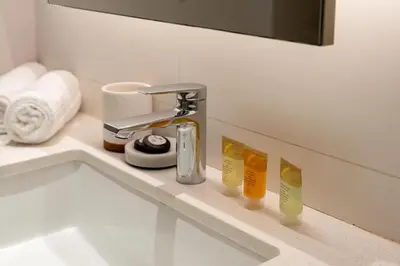 a bathroom sink with a faucet and toothbrushes at Ahlan HH - Beautiful 1BR Home with Pool View - Belgravia III, JVC in Dubai