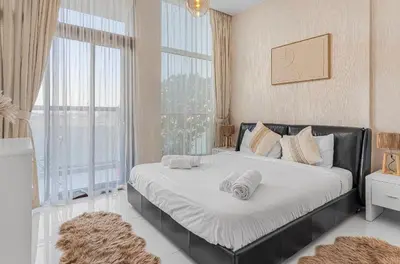a large bed in a room with a large window at Trendy Fully Equipped Beautiful Apartment for Four near to Metro in Dubai