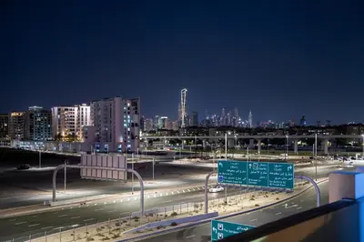 a highway at night with a city in the background at Trendy Fully Equipped Beautiful Apartment for Four near to Metro in Dubai
