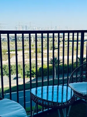 a patio with a table and chairs on a balcony at Sunny 1 Bedroom Apartment in Dubai Hills Estate in Dubai