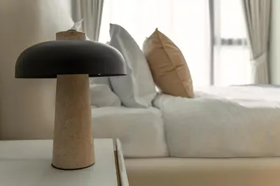 a black lamp sitting on a table next to a bed at Aykon Luxury Sky Collection Suites with Sea View by HSHOME in Dubai