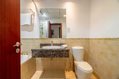 a bathroom with a toilet and a sink and a mirror at GuestReady - Enchanting retreat in JBR in Dubai