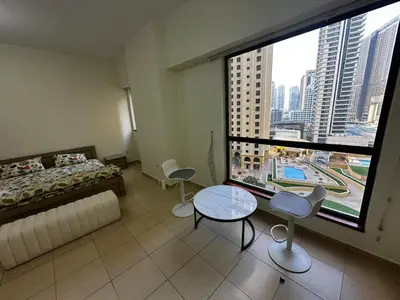 a bedroom with a bed and a table and a large window at HOT MASTER BED ROOM - JBR WALK Marina in Dubai