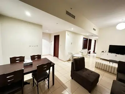 a dining room and living room with a table and chairs at HOT MASTER BED ROOM - JBR WALK Marina in Dubai