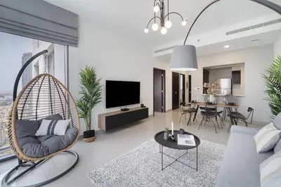 a living room with a swing chair and a living room at HAVN - 1 Bedroom in Downtown, Burj Khalifa View in Dubai