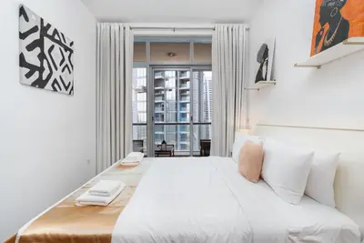 a bedroom with a large white bed with a window at Vacay Lettings - 1 BHK - Iris Blue Dubai Marina in Dubai