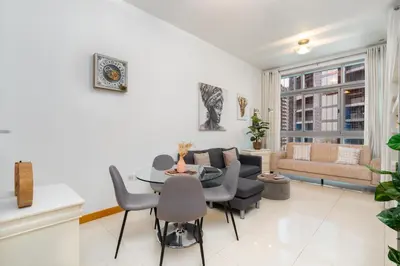 a living room with a table and a couch at Vacay Lettings - 1 BHK - Iris Blue Dubai Marina in Dubai