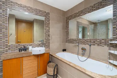 a bathroom with a tub and a sink and a mirror at Vacay Lettings - 1 BHK - Iris Blue Dubai Marina in Dubai
