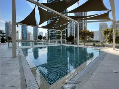 a large swimming pool in a building with a city at Vacay Lettings - 1 BHK - Iris Blue Dubai Marina in Dubai