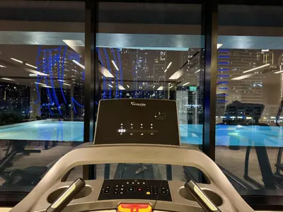 a laptop sitting on top of a treadmill in front of a window at Burj Khalifa Poolview 1BR Apartment for 4 people in Dubai