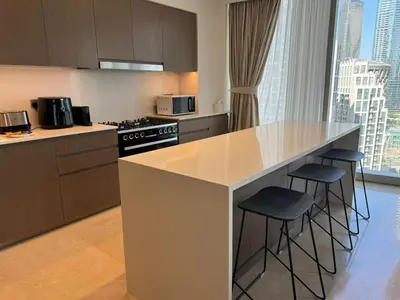 a kitchen with a large island with stools in it at Luxury Grande Downtown Full Burj khalifa Views in Dubai