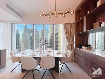 a dining room with a table and chairs and a large window at Luxury Grande Downtown Full Burj khalifa Views in Dubai