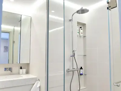 a bathroom with a shower with a glass door at Beachfront Townhouse SEA BREEZE in Dubai