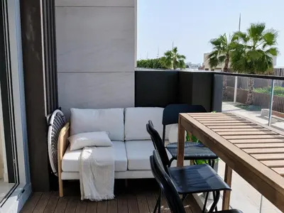 a couch on a balcony with a table and chairs at Beachfront Townhouse SEA BREEZE in Dubai