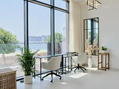 a dining room with a glass table and white chairs at Beachfront Townhouse SEA BREEZE in Dubai