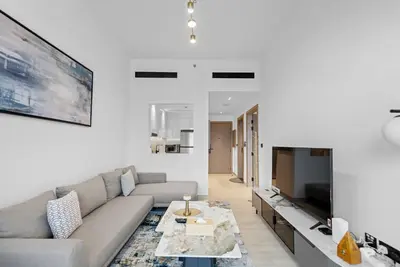 a living room with a couch and a tv at Magnificent - New Modern 1BR in Binghatti Heights in Dubai