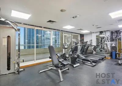 a gym with cardio equipment and a view of the city at Stylish Renovated 1-Bedroom in Mayfair Residency in Dubai