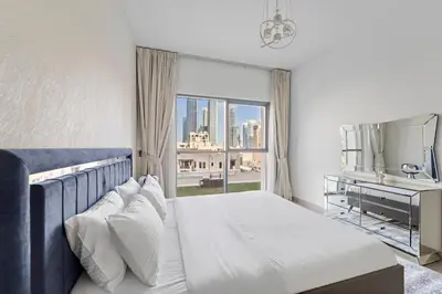 a bedroom with a bed and a desk and a window at 2BR plus Maid Bellevue Tower 1, Burj Khalifa View in Dubai