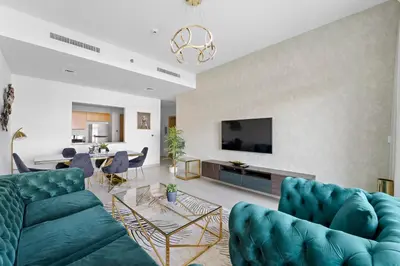 a living room with two blue couches and a tv at 2BR plus Maid Bellevue Tower 1, Burj Khalifa View in Dubai