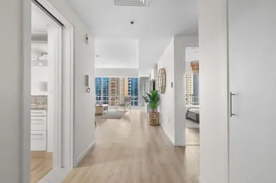 a living room with white walls and a hallway with wood floors at Superb Marina Views I Sleeps 5 in Dubai