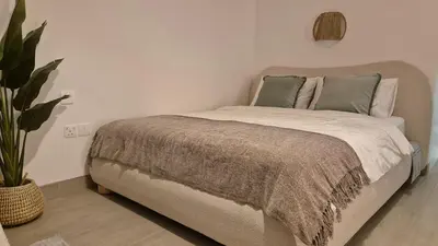a bedroom with a bed and a potted plant at Deluxe Studio - Stylish & Cosy in Luma22 in Dubai
