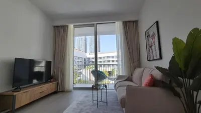 a living room with a couch and a flat screen tv at Deluxe Studio - Stylish & Cosy in Luma22 in Dubai