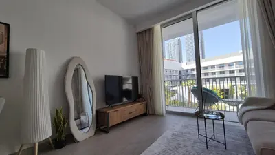 a living room with a tv and a large window at Deluxe Studio - Stylish & Cosy in Luma22 in Dubai