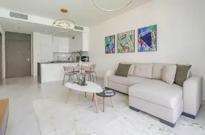 a living room with a white couch and a table at District one Full Water view Apartment in Dubai