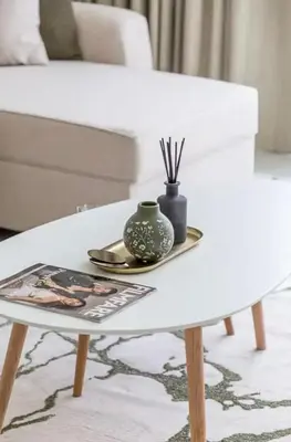 a white coffee table with a vase on top of it at District one Full Water view Apartment in Dubai