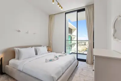 a bedroom with a bed and a large window at Stylish 1 Bedroom in Binghatti Lavender JVC in Dubai