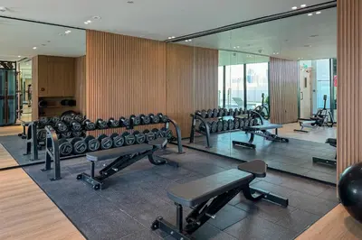 a row of chairs in a gym with mirrors at Stylish 1 Bedroom in Binghatti Lavender JVC in Dubai
