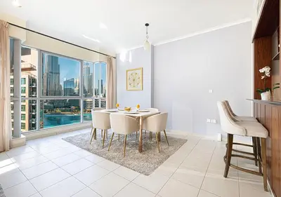 a dining room with a table and chairs and a large window at Stunning 2 BR Burj Khalifa Fountain Views in Dubai