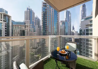 a balcony with a table and chairs and a view of a city at Stunning 2 BR Burj Khalifa Fountain Views in Dubai
