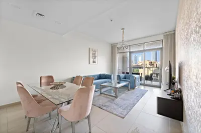 a dining room and living room with a table and chairs at 2BR plus Maid Bellevue Tower 1, Burj Khalifa View in Dubai