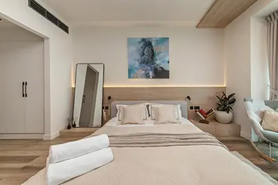 a bedroom with a large bed and a chair at Heart of Dubai in Dubai