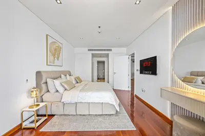 a white bedroom with a bed and a staircase at Burj View Luxury 1BR - Full Sea View Private Beach - Anantara Palm in Dubai