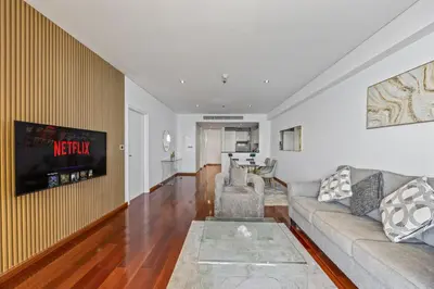 a living room with a couch and a tv at Burj View Luxury 1BR - Full Sea View Private Beach - Anantara Palm in Dubai