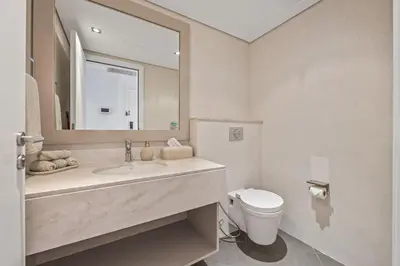a bathroom with a sink and a toilet and a mirror at Burj View Luxury 1BR - Full Sea View Private Beach - Anantara Palm in Dubai