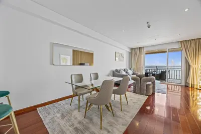 a living room with a table and chairs at Burj View Luxury 1BR - Full Sea View Private Beach - Anantara Palm in Dubai